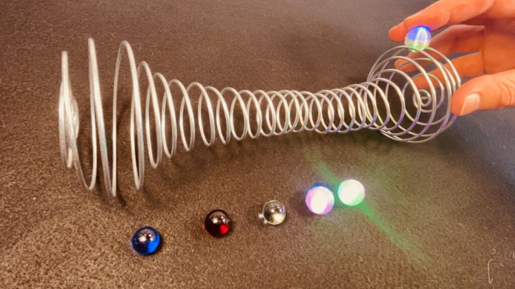 Zorbit Barbell by Super Flow Yo is a hand-held spiral barbell cage for spinning bright LED marbles for a lightshow in your hand.